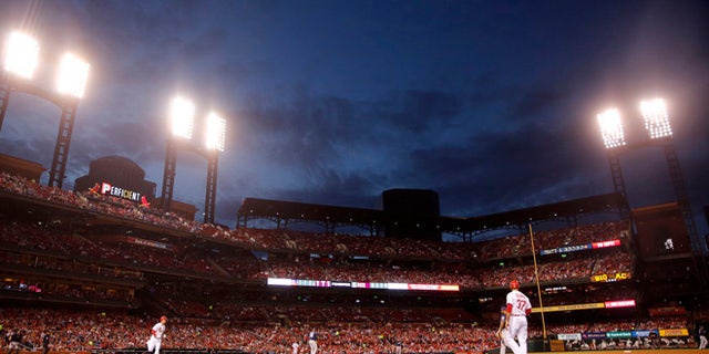 St. Louis Cardinals' Stephen Piscotty heads to first on a single as dusk falls over Busch Stadium during the fourth inning of a baseball game against the Milwaukee Brewers Tuesday, May 2, 2017, in St. Louis. (AP Photo/Jeff Roberson)