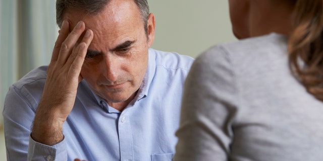 Depressed Mature Man Talking To Counsellor