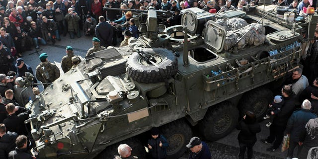 March 24, 2015: People gather around an U.S. Army 2nd Cavalry Regiment "Stryker" armored fighting vehicle in Bialystok, Poland, which is a part of the U.S. military "Dragoon Ride" operation. Dragoon Ride is aimed at demonstrating commitment to NATO allies in light of Russia's aggression in Ukraine, according to the U.S. Army.