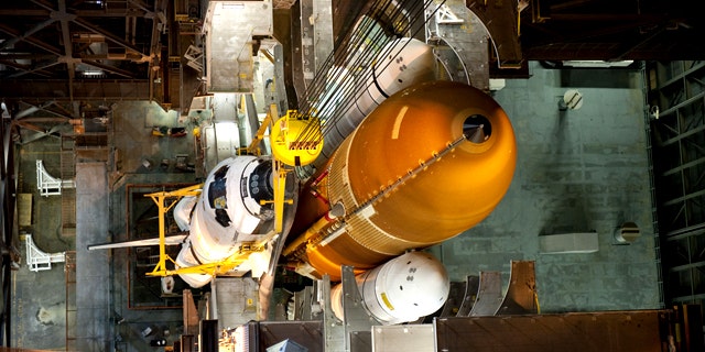 In the Vehicle Assembly Building at NASA's Kennedy Space Center in Florida, shuttle Endeavour is lowered into place where it is being attached to its external fuel tank and solid rocket boosters, already positioned on the mobile launcher platform. The shuttle is slated to launch its final mission STS-134 on April 19, 2011.