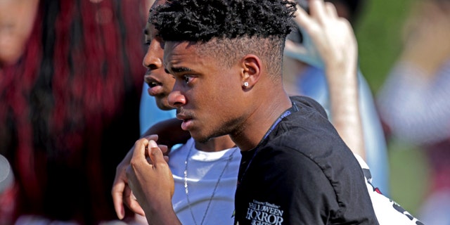 Students released from a lockdown walk away following a shooting at Marjory Stoneman Douglas High School in Parkland, Fla., on Wednesday, Feb. 14, 2018.