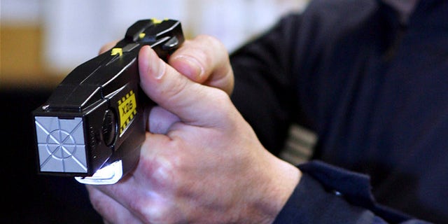 An unidentified French Police officer presents a stun gun which is to be used experimentally by the anti-criminal brigades, in Paris, Tuesday Sept. 20, 2005. (AP Photo/Remy de la Mauviniere)