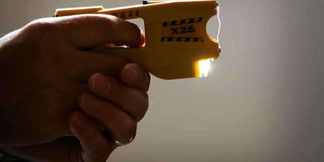 BLACKPOOL, UNITED KINGDOM - MAY 16: A representative from Taser International fires the companies latest X26 stun gun during the Police Federation Conference at Winter Gardens on May 16, 2007 in Blackpool, England. British Home Secretary John Reid announced today that more Taser guns could be deployed on the streets of the UK by frontline police officers. The Taser's which stun a person with up to 50,000 volts, and can currently only be carried by armed response officers have some under harsh criticism from Amnesty International who claim more than 70 deaths in Canada and America have been linked to the weapon. (Photo by Christopher Furlong/Getty Images)