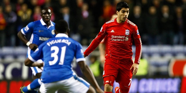 Liverpool's Luis Suarez, right, vies for the ball against Wigan's Maynor Figueroa, center, during their English Premier League soccer match at DW Stadium, Wigan, England, Wednesday Dec. 21, 2011. (AP Photo/Tim Hales)