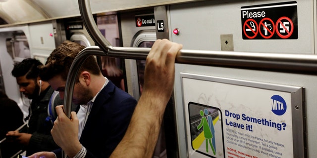 Commuters stand on a subway train near an anti-nazi sticker in New York, U.S., June 19, 2017. REUTERS/Lucas Jackson - RTS17QN1