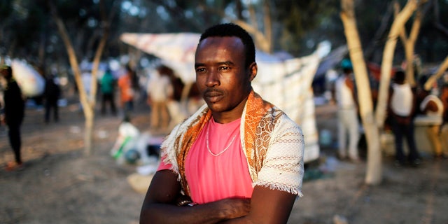 An African asylum seeker stands in the shade of trees during a protest after leaving Holot open detention centre in southern Israel's Negev desert.