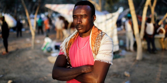 An African asylum seeker stands in the shade of trees during a protest after leaving Holot open detention centre in southern Israel's Negev desert.