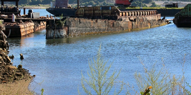 In this Monday, Aug. 22, 2016, photo, rusting remnants of an old Russian submarine that once was used as a floating museum until it sank in 2007, remains in the Providence river in Providence, R.I. The state wants it gone.
