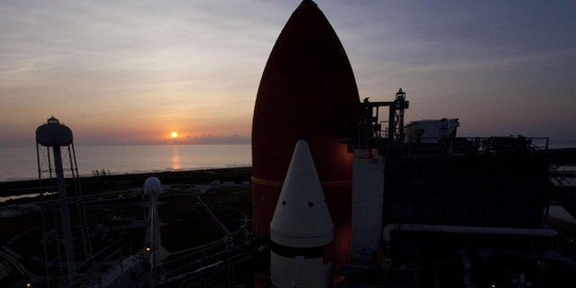 The sun rises over the Atlantic Ocean at NASA's Kennedy Space Center in Florida, illuminating space shuttle Atlantis' external fuel tank and solid rocket boosters on Launch Pad 39A. Launch is scheduled to take place for the STS-135 mission on July 8, 2011. This image was taken on June 23, 2011.