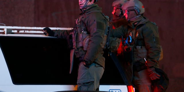 Denver SWAT team members survey Broncos fans celebrating Denver's win in the Super Bowl.
