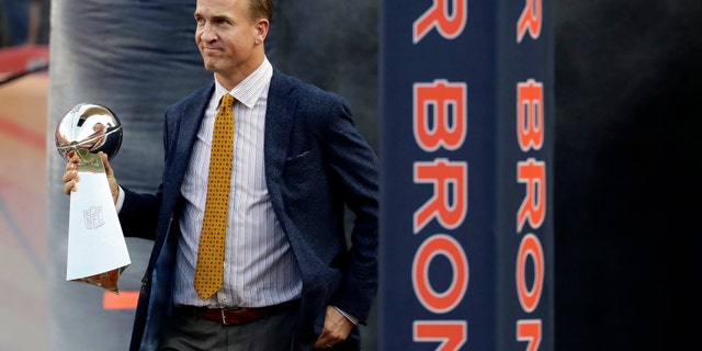 Sept. 8, 2016: Former Denver Broncos quarterback Peyton Manning carries the Vince Lombardi Trophy from Super Bowl 50 onto the field prior to an NFL football game against the Carolina Panthers in Denver.