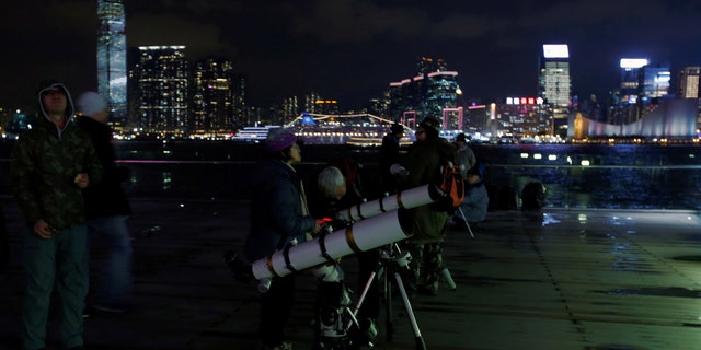 People set up telescopes on the waterfront for the super blue moon and eclipse in Hong Kong, China Jan. 31, 2018. (REUTERS/Bobby Yip)