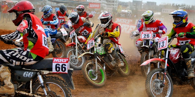 Riders turn a corner on their motorcycles during the National Supercross Championship in the southern Indian city of Bangalore November 30, 2014. More than 50 riders on Sunday took part in the national-level motorcycle championship. REUTERS/Abhishek N. Chinnappa (INDIA - Tags: SPORT MOTORSPORT) - RTR4G45G