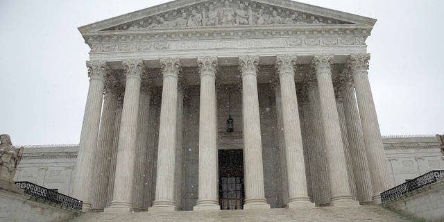 WASHINGTON, DC - MARCH 05: A government employee shovels newly fallen snow from the steps of the U.S. Supreme Court March 5, 2015 in Washington, DC. The Washington DC area is expected to receive 4-8 inches of snow during the day. (Photo by Win McNamee/Getty Images)