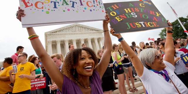 Demonstrators celebrate after declaring that same-sex couples have the right to marry anywhere in the United States outside the Supreme Court in Washington on June 26, 2015. (AP Photo/Jacquelyn Martin)