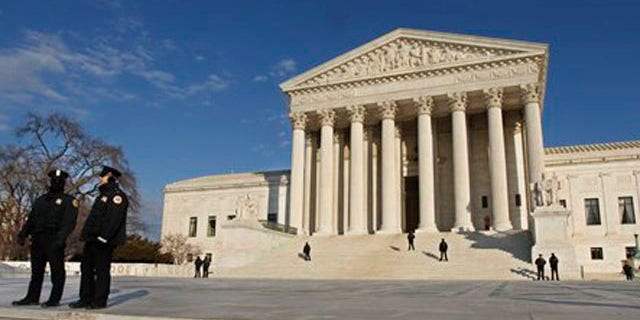 Security personnel stand guard as anti-abortion activists gather in front of the U.S. Supreme Court, in Washington, Monday, Jan. 24, 2011, during a rally against Roe v. Wade on the anniversary of the U.S. Supreme Court decision. (AP Photo/Manuel Balce Ceneta)