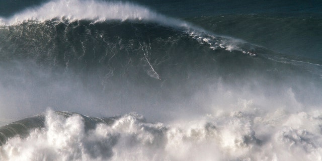 Brazilian surfer Rodrigo Koxa rides what has been judged the biggest wave ever surfed, at the Praia do Norte, or North beach, in Nazare, Portugal.