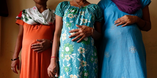 Surrogate mothers (L-R) Daksha, 37, Renuka, 23, and Rajia, 39, pose for a photograph inside a temporary home for surrogates in India (REUTERS/Mansi Thapliyal).