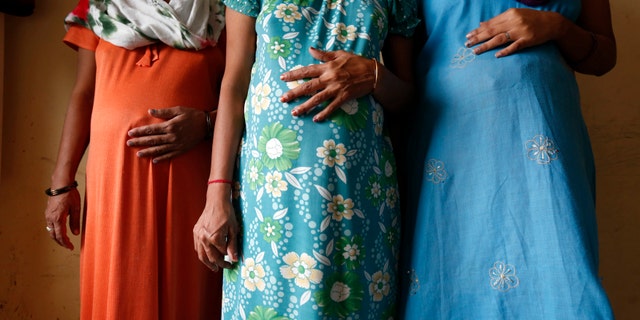 Surrogate mothers (L-R) Daksha, 37, Renuka, 23, and Rajia, 39, pose for a photograph inside a temporary home for surrogates in India (REUTERS/Mansi Thapliyal).