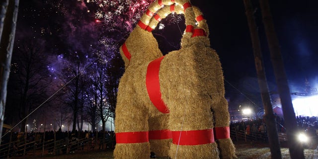 A traditional Christmas goat is unveiled in Gavle, Sweden, Sunday, Nov. 27, 2016. Sweden's Christmas Goat - a giant decorative goat made of straw and wood - is celebrating its 50th birthday, but revelers are being asked to keep the candles away. Every Christmas season since 1966, the city of Gavle in central Sweden builds a giant version of the straw goat, an ancient Scandinavian Yuletide character that precedes Santa Claus as a bringer of gifts, but it also attracts arsonists and seldom survives the season without someone trying to burn it down. To improve its odds this year, the goat set up on Sunday was equipped with closed-circuit TV. (Pernilla Wahlman/TT News Agency via AP)
