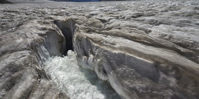 File photo: Water from the melting glacier runs down through a hole in the Aletsch Glacier on the Jungfraufirn Glacier, Switzerland, August 28, 2015. One of Europe's biggest glaciers, the Great Aletsch coils 23 km (14 miles) through the Swiss Alps - and yet this mighty river of ice could almost vanish in the lifetimes of people born today because of climate change. The glacier, 900 metres (2,950 feet) thick at one point, has retreated about 3 km (1.9 miles) since 1870 and that pace is quickening. (REUTERS/Denis Balibouse)