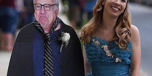 Allison Closs poses with a cardboard cutout of Danny DeVito that she took to her school's prom.