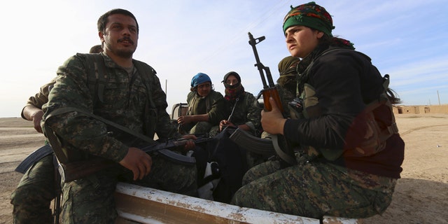 Feb. 17, 2016: Fighters from the Democratic Forces of Syria carry their weapons on the back of a pick-up truck in Ghazila village after taking control of the town from Islamic State forces in the southern countryside of Hasaka, Syria.