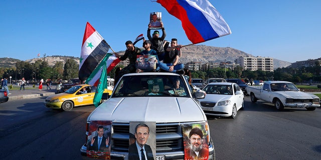 A convoy of cars with pro-government supporters in Damascus.