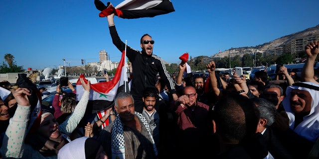 Syrian government supporters took to the streets of Damascus, waving flags and chanting slogans against U.S. President Trump during demonstrations.