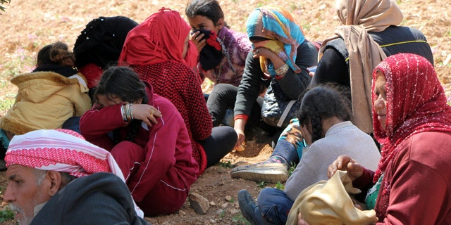 Syrians fleeing fighting between Turkish troops and Syrian Kurdish militia rest in a field between Afrin and Azaz, Syria, March 14, 2018