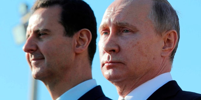 Russian President Vladimir Putin, right, and Syrian President Bashar Assad watching troops march at the Hemeimeem air base in Syria.