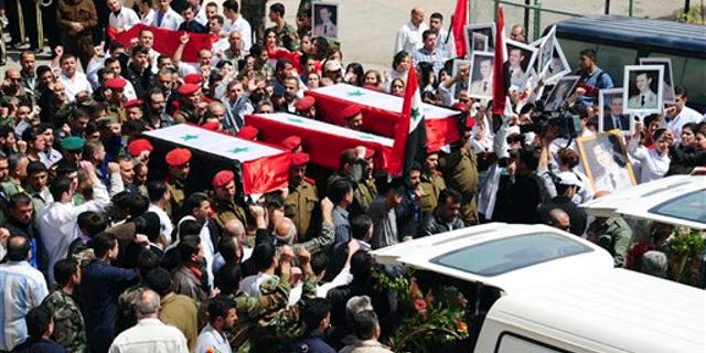 April 26: In this photo released by the Syrian official news agency SANA, Syrian military police carry coffins as they prepare to send the bodies of fifteen killed soldiers and security force members to their hometowns for burial, at a military hospital in Damascus, Syria. The agency did not report the circumstances of their deaths but they are believed to have been victims of the ongoing civil unrest against the government. (AP/SANA)