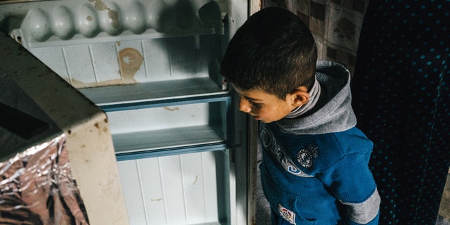 Jan. 24, 2016: A Syria refugee boy opens an empty fridge inside his family tent in Kawergosk refugee camp in northern Iraq.