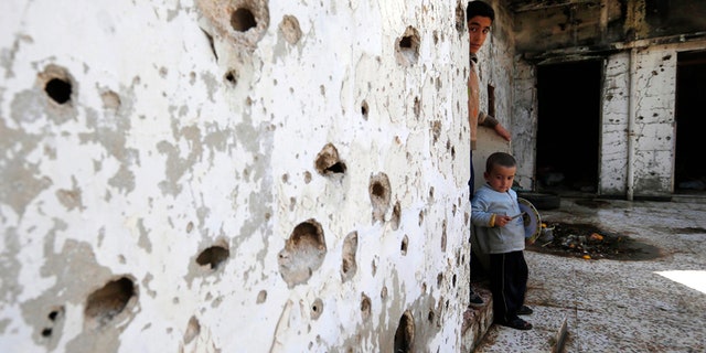 Feb. 26, 2016: Syrian boys are seen inside their destroyed house at neighborhood of Baba Amr in Homs, Syria.