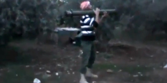 Nov. 27 2012: A Free Syrian Army fighter fires his weapon toward a military tank, unseen, in Daraa, Syria.