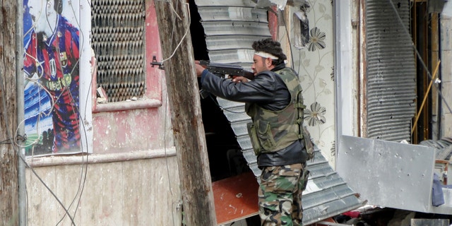 March 28, 2013 - Free Syrian Army fighters take position in Aleppo's Salaheddine district.