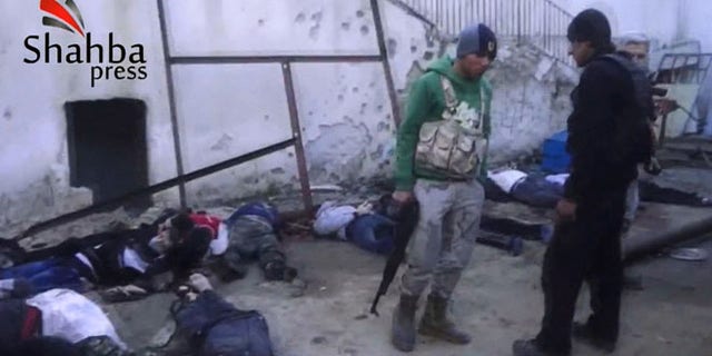 This image made from citizen journalist video posted by the Shahba Press on Wednesday, Jan. 8, 2014, which has been verified and is consistent with other AP reporting, shows rebel fighters standing next to dead bodies after they ousted Islamic State of Iraq and the Levant (ISIL) from their headquarters in a hospital in the Syrian city of Aleppo. Activists said the people were killed by fighters from the Al Qaeda affiliate, which is trying to build Islamic rule across Syria.