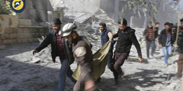 Civil Defense workers and Syrian citizens carry a dead body in the neighborhood of Seif al-Dawleh in Aleppo, Syria, Nov. 19, 2016.