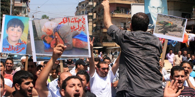 July 15: Lebanese protesters shout slogans as they carry banners in Arabic that read:" you are in heaven my son," center, "the martyr Hamza el-Khatib," left, and "Daraa mass graves," right, during a rally in solidarity with Syrian anti-government protesters in the northern city of Tripoli, Lebanon. Syrian security forces fired on protesters in the capital and other major cities Friday, killing at least 14 people as hundreds of thousands gathered for some of the largest anti-government rallies since the uprising began in March, witnesses and activists said.