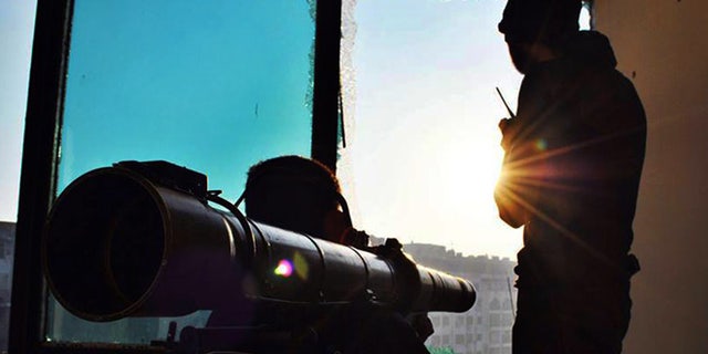 June 18, 2013: This citizen journalism image provided by Lens Young Homsi, which has been authenticated based on its contents and other AP reporting, shows Syrian rebels using a rocket launcher to attack Syrian soldiers loyal to Syrian president Bashar Assad, in Homs province, Syria. Syrian warplanes bombed rebel positions near a contested military air base in the north of Syria on Tuesday, activists said, while President Bashar Assad's forces nearby pressed ahead with an offensive against opposition fighters in the country's largest city Aleppo.