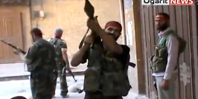 Sept. 28, 2012: In this image taken from video obtained from Ugarit news, which has been authenticated based on its contents and other AP reporting, Syrian rebels gather as they engage government forces in Aleppo, Syria.