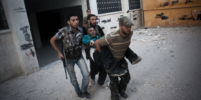 Sept 8, 2012: Free Syrian Army soldiers help a severely wounded fighter after he was shot by a Syrian Army sniper in the Izaa district of Aleppo, Syria.