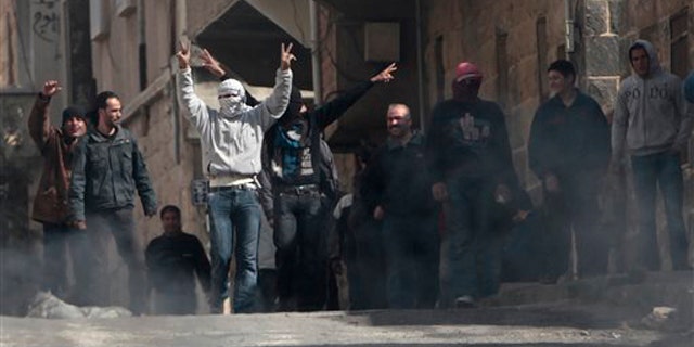 Anti-Syrian government protesters flash V sign as they protest in the southern city of Daraa, Syria, March 23.