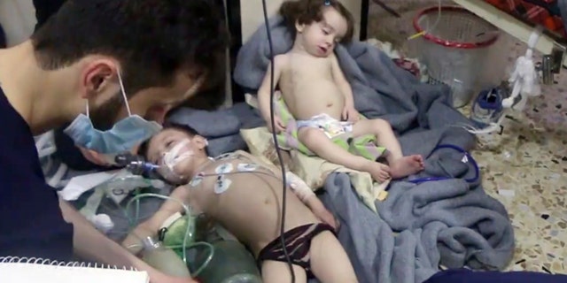 This image made from video released by the Syrian Civil Defense White Helmets, which has been authenticated based on its contents and other AP reporting, shows medical workers treating toddlers following an alleged poison gas attack in the opposition-held town of Douma, in eastern Ghouta, near Damascus, Syria, Sunday, April. 8, 2018.