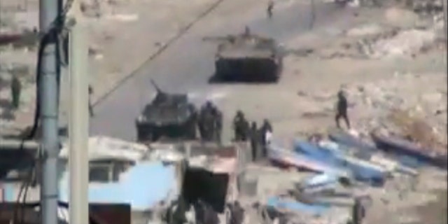 Aug. 17: This image taken from amateur video made available Tuesday purports to show armored vehicles and troops in  Latakia, Syria on Monday. Activists say 15 people died in shootings across Syria Monday including at least five in the coastal city of Latakia where military operations where in their fourth day.