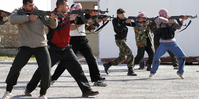 Feb. 14, 2012: FILE- In this file photo, Syrian rebels aim during a weapons training exercise outside Idlib, Syria.