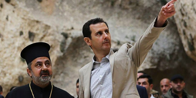 April 20, 2014: In this file photo, released by the Syrian official news agency SANA, Syrian President Bashar Assad, right, visits the Christian village of Maaloula, near Damascus, Syria.
