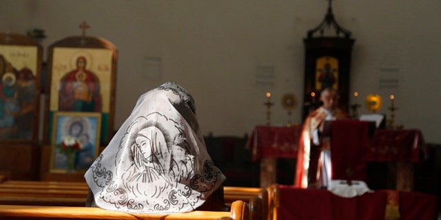 FILE: An Assyrian woman attends a mass in solidarity with the Assyrians abducted by Islamic State fighters in Syria earlier the inside Ibrahim al-Khalil church in Jaramana, eastern Damascus on March 1, 2015.