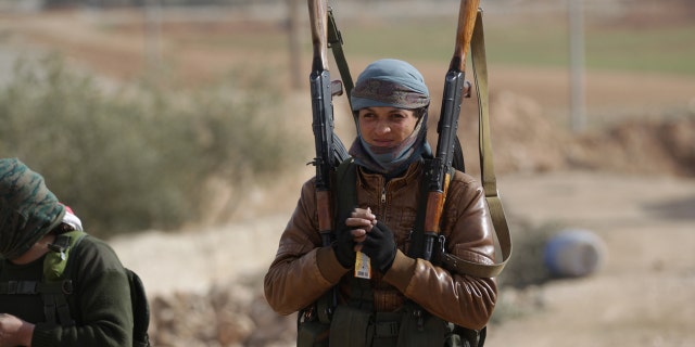 A rebel fighter carries his weapons on the outskirts of the northern Syrian town of al-Bab, Syria January 26, 2017. REUTERS/Khalil Ashawi - RTSXILL
