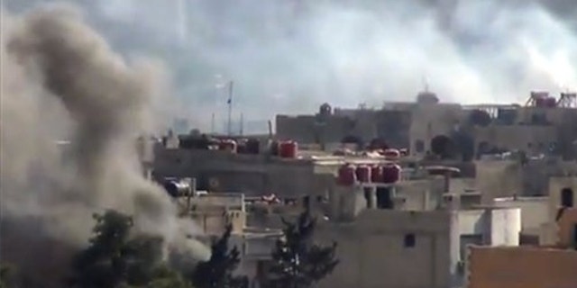 Sept. 4, 2013: Smoke rises from buildings due to heavy clashes between Free Syrian army fighters and government forces in Daraya, a suburb of Damascus, Syria.